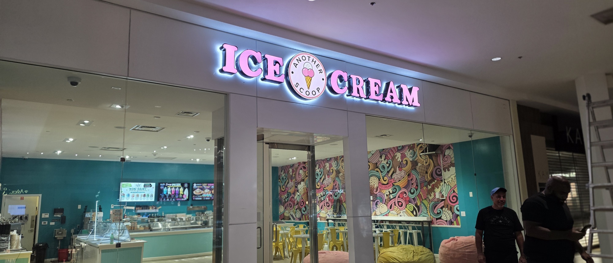 The finished Another Scoop storefront with the sign lit across the entrance